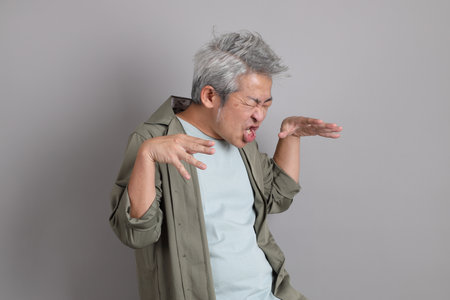 The 40s Asian man with smart casual clothes standing on the grey background.の写真素材