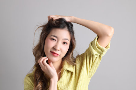 The Asian woman in casual dressed standing on the grey background.の写真素材