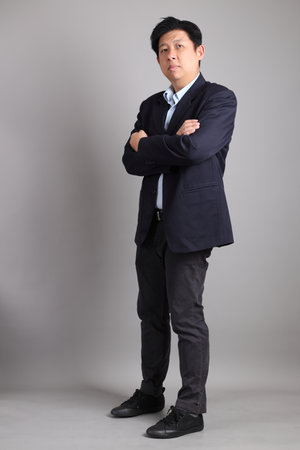 The Asian Businessman with formal dressed with gesture of standing on the gray background.の写真素材