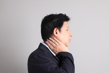 The Asian Businessman with formal dressed with gesture of get dressed on the gray background.の写真素材