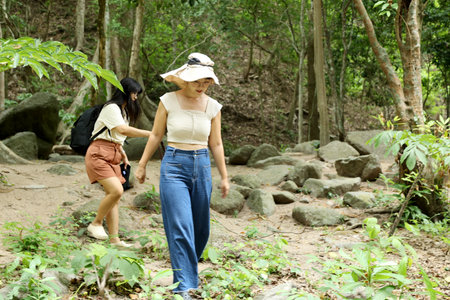 Two Asian siblings spending time together in the forest during the daytime in the summer season.の写真素材