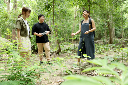 Three Asian friends spending time together in the forest during the daytime in the summer season.