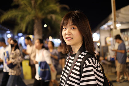 Young asian woman enjoying taking photos at the night market Bangkok, Thailand. City lifestyle, Staycation. Bokeh on background. Touristの写真素材