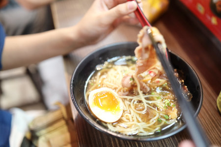 Eating Shoyu KAKUNI RAMEN with an egg in japanese restaurant.の写真素材