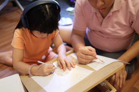 The East Asian father and daughter spending time together in the house.の写真素材