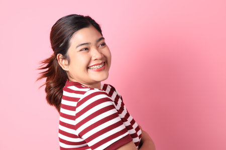 The Southeast Asian woman with braces standing on the colorful background.の写真素材