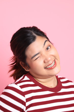 The Southeast Asian woman with braces standing on the colorful background.の写真素材