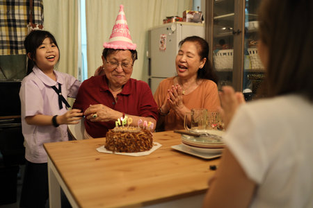 The Asian family gathered for a grnadfather birtday in the dining room, enjoying food together and sharing happy moments.の写真素材