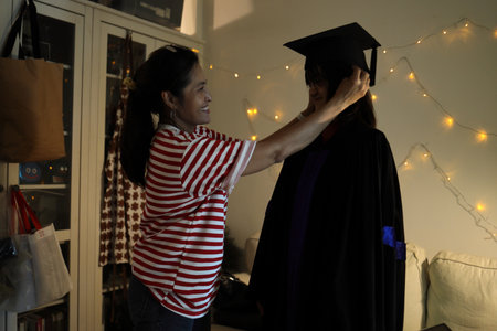 The single Asian mother celebrating her daughter graduation in the night. Low key photography.