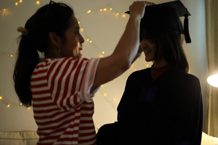 The single Asian mother celebrating her daughter graduation in the night. Low key photography.の写真素材