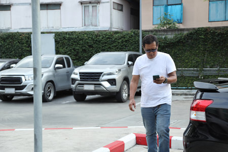 The Southeast Asian person using smart phone walking on the footpath.の写真素材