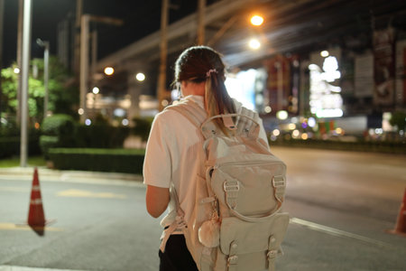 The young East Asian woman using a smartphone in the city at night.