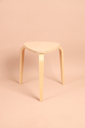 The round wooden chair is on the brown background.