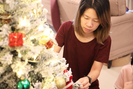 An East Asian family decorating the Christmas tree for the upcoming Christmas.の写真素材