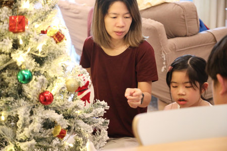 An East Asian family decorating the Christmas tree for the upcoming Christmas.の写真素材