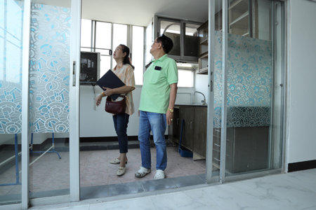 An East Asian senior couple checking the condominium room after renovations before selling.