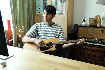 The man is learning to play the guitar for the first time from the internet