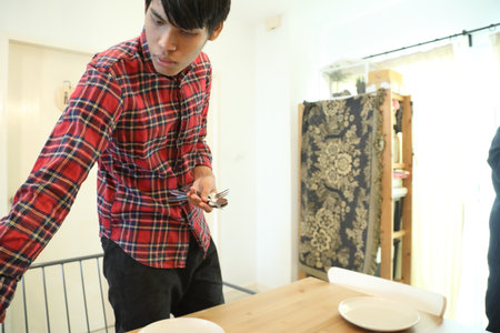 Two Southeast Asian friends are helping each other prepare food from the delivery order.の写真素材