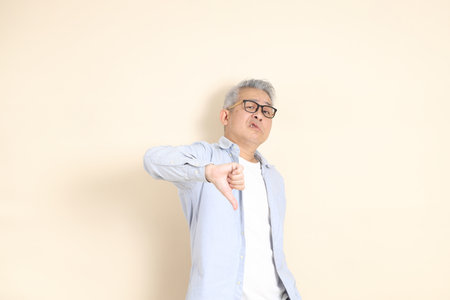 The portrait of an East Asian man with gray hair and glasses, dressed in smart casual clothes.