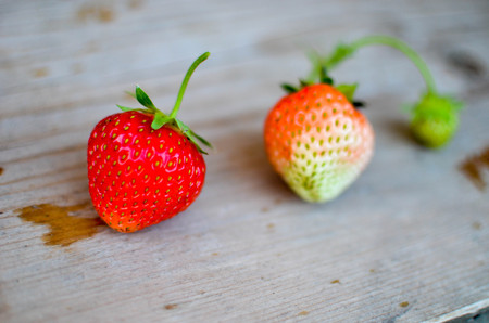 Strawberries red and green on the wood backgroundsの写真素材