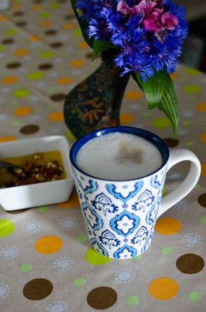 A cup of hot coffee with milk, flowers, honey and book. Romantic background with retro filter effectの写真素材