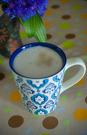 A cup of hot coffee with milk, flowers, honey and book. Romantic background with retro filter effectの写真素材