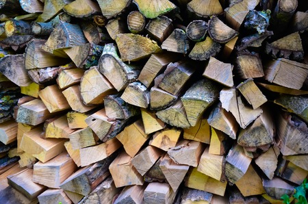 Natural wooden background - closeup of chopped firewood. Firewood stacked and prepared for winter Pile of wood logsの写真素材