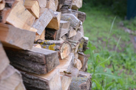 Natural wooden background - closeup of chopped firewood. Firewood stacked and prepared for winter...