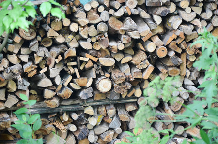 Natural wooden background - closeup of chopped firewood. Firewood stacked and prepared for winter...