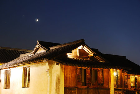 Quiet night, curved moon, bright houseの写真素材