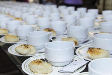 Coffee cup and bun arrange for breaking times to meet.