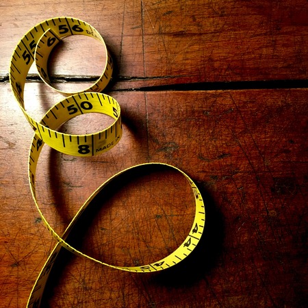 Yellow tape measure on wood backgroundの写真素材