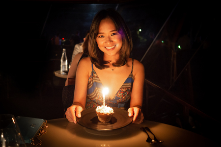 Young woman celebrating her birthday at a dinner in a nice restaurantの写真素材