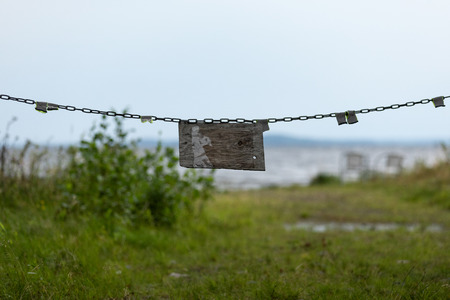 Vintage wooden sign blocking a road with a chainの写真素材