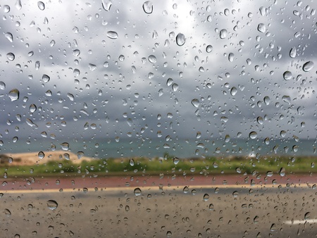 Dark clouds seen through raindrop windowの写真素材