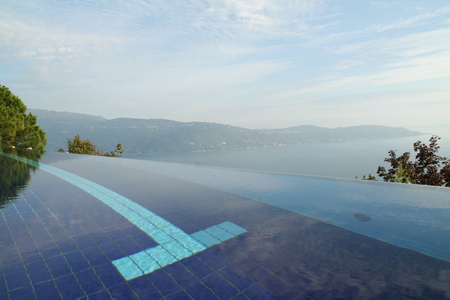 Infinity pool looking out over lake and mountainの写真素材