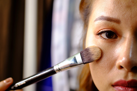 Woman Thailand holding a makeup powder brush to her acne face - No Effect - (Selective focus)の写真素材
