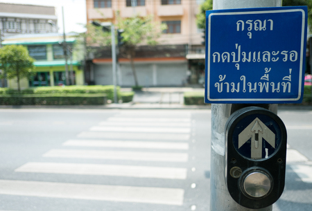 push button for Red traffic light in Thailand. thai language -- (Selective focus)の写真素材