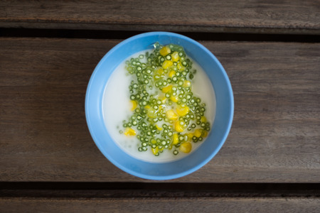 Tapioca pudding or Sakoo (Thai dessert) with coconut milk on wood table (Selective focus)の写真素材