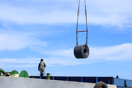 Overhead crane at port lifting heavy steel coil ship to vesselの写真素材