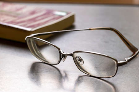 Glasses and books on the tableの写真素材