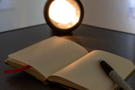 Notebook and flashlight on the tableの写真素材