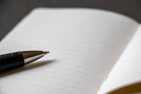 Opened notebook and ballpoint pen nibの写真素材