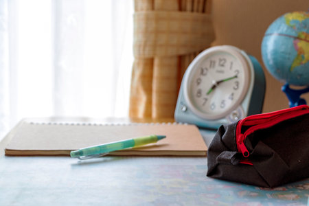 Clock and writing tools on study deskの写真素材