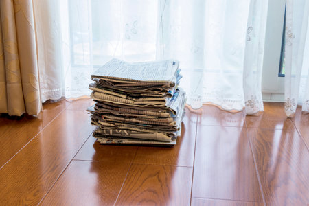Old newspapers piled up by the windowの写真素材