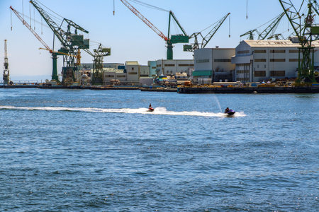 Water motorcycles sprinting beside the shipyard at Kobe Port