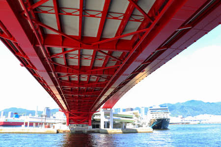 Pass under a big red bridge at Kobe Portの写真素材