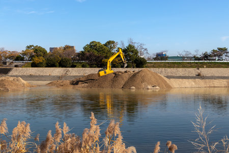 Hydraulic excavator working on the riverbankの写真素材