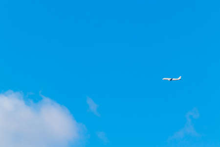 An airplane flying in blue skyの写真素材