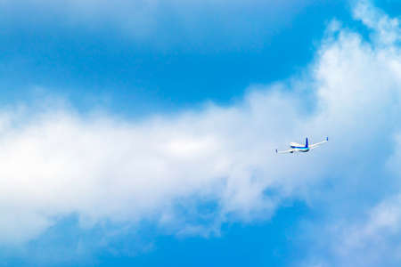 An airplane flying while turning in the blue sky